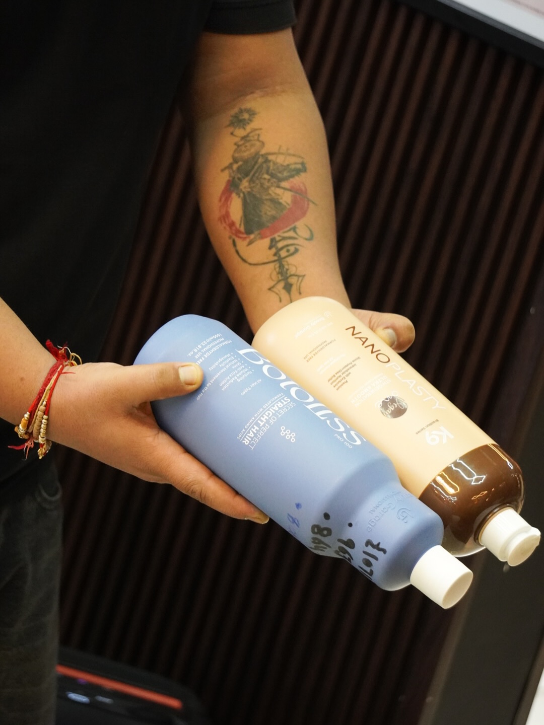 Professional hair care products in hands showing premium quality treatments used at Music Salon